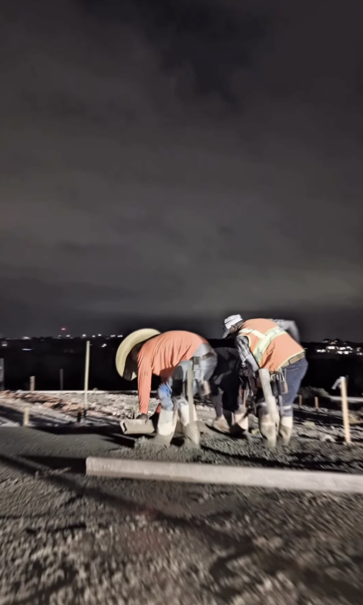 Crew members hand-finishing fresh concrete through the night