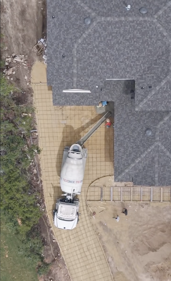 Overhead view of concrete delivery beside a home